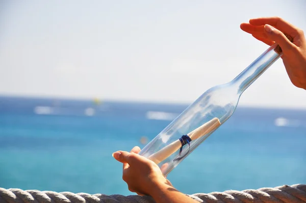 Bouteille avec un message dans les mains — Photo