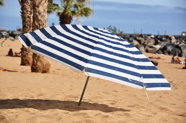 Striped umbrella on the beach — Stock Photo, Image