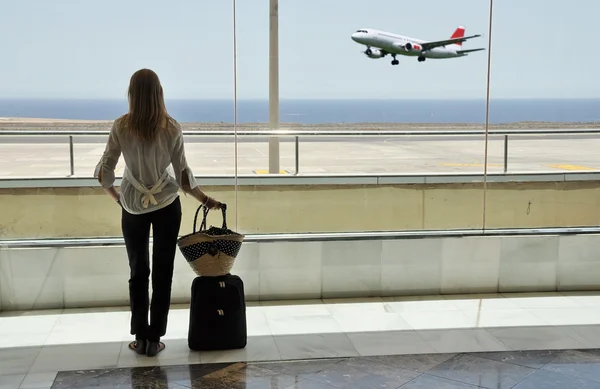 Ragazza alla finestra dell'aeroporto guardando l'oceano — Foto Stock