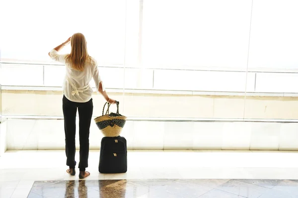 Menina na janela do aeroporto olhando para o oceano — Fotografia de Stock