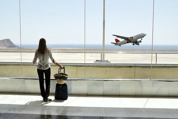 Menina na janela do aeroporto olhando para o oceano — Fotografia de Stock