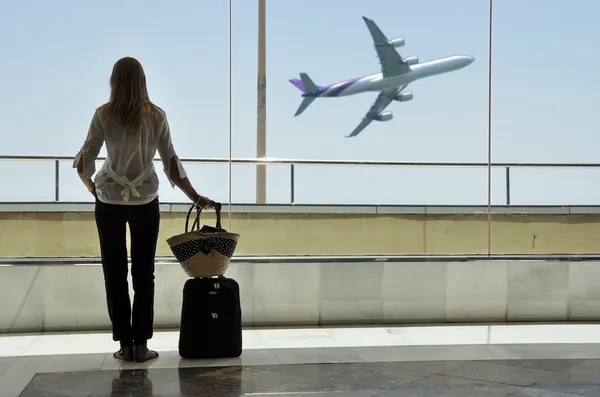 Menina na janela do aeroporto Fotos De Bancos De Imagens