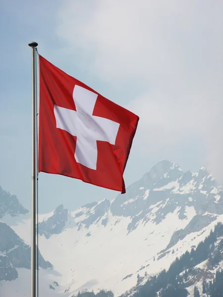 Švýcarská vlajka proti zasněžené Alpy — Stock fotografie