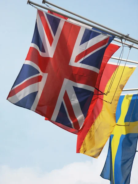 National flags against blue sky — Stock Photo, Image