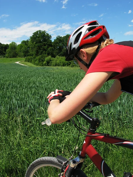 Giovane donna in sella a una mountain bike — Foto Stock