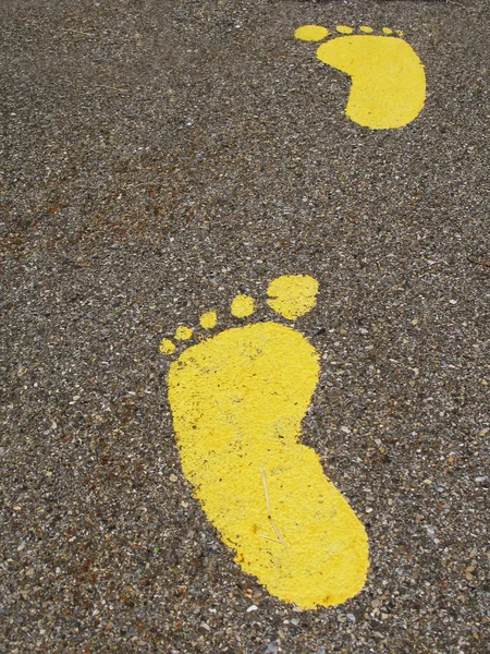 Żółta stopa na asfalcie — Zdjęcie stockowe