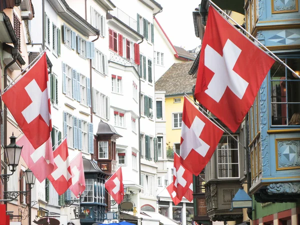 Alte Strasse in Zürich mit Fahnen für die Schweizerische Nationalflagge geschmückt — Stockfoto