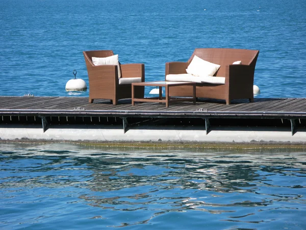Två, armcairs, på, a, trädäck, mot, vatten — Stockfoto