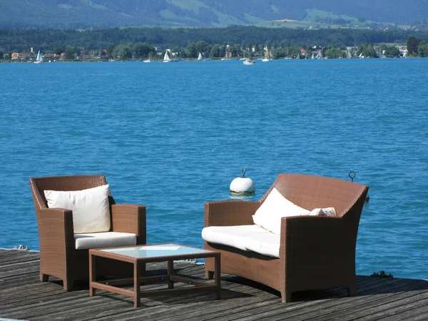 Two armcairs on a wooden deck against water. Lake Thun, Switzerl — Stock Photo, Image