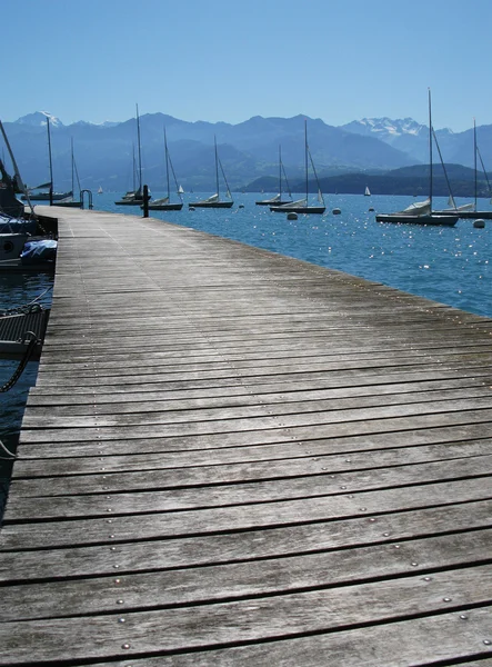 Dřevěné molo proti jezero thun a Alpy. Švýcarsko — Stock fotografie