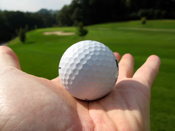 Golf ball op de palm van een hand — Stockfoto