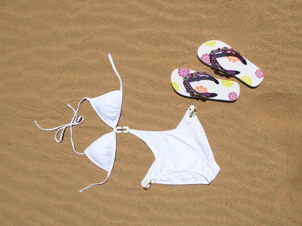 Bikini und Flip-Flops im Sand — Stockfoto