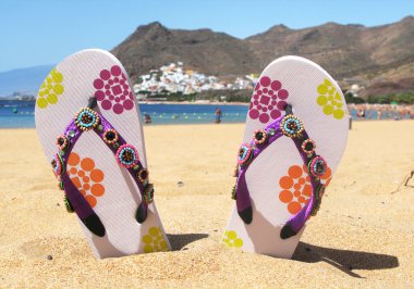 Flip-flops in the sand of Teresitas beach. Tenerife island, Cana clipart