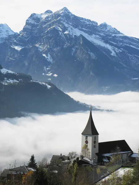 Rural kerk in amden tegen besneeuwde Alpen, Zwitserland — Stockfoto