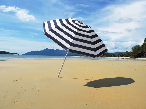 Striped umbrella on a sandy beach of Langkawi island — Stock Photo, Image