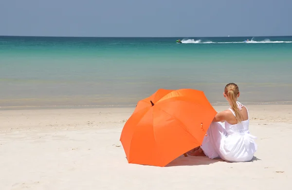 砂浜のビーチにオレンジ色の傘を持つ少女 — ストック写真