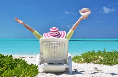 okyanusa bakarak şezlong üzerinde bir kabuk olan kız. Exuma, bah