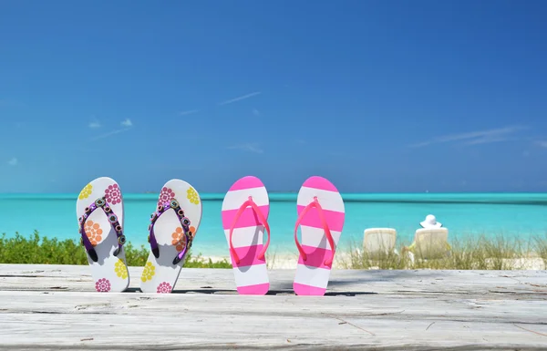 Δύο ζεύγη flip-flops ενάντια στον ωκεανό. Exuma, Μπαχάμες — Φωτογραφία Αρχείου