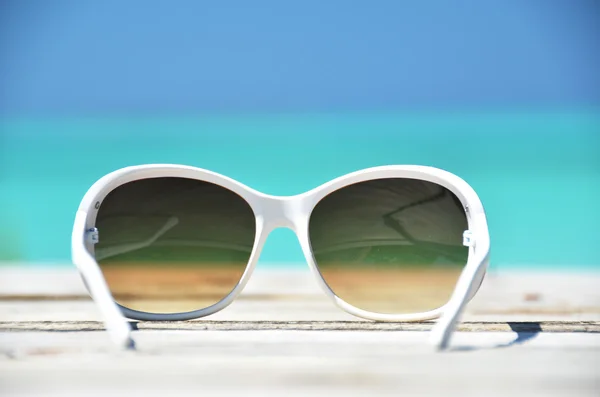 Sunglasses against tropical ocean — Stock Photo, Image