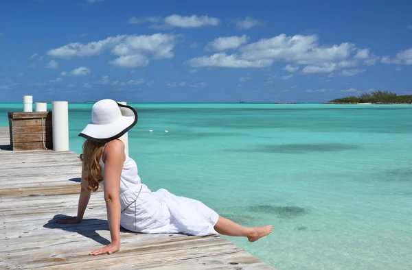 Dziewczyna na drewniane molo patrząc do oceanu. Exuma, Bahamy — Zdjęcie stockowe