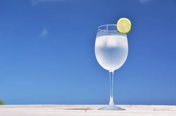 Bicchiere d'acqua contro il cielo blu — Foto Stock