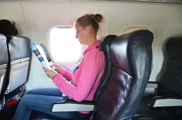 Dívka čtení v letadle — Stock fotografie