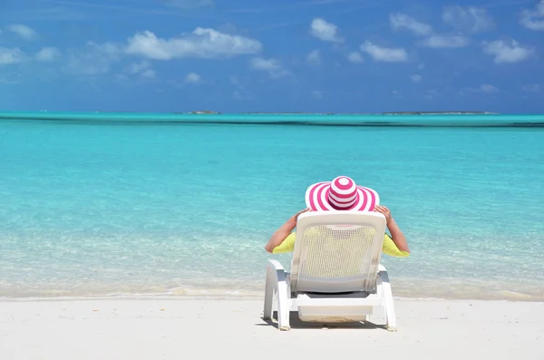 Menina em um chapéu listrado na praia de Exuma, Bahamas — Fotografia de Stock