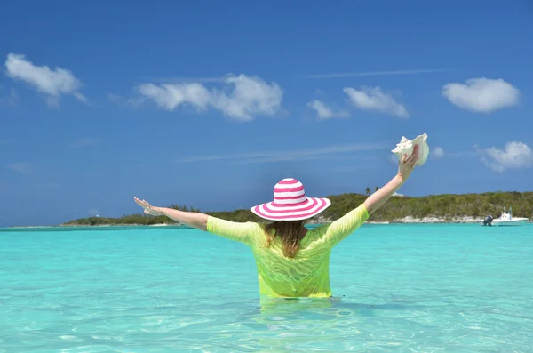 Turqouise 水中大西洋の貝殻を持つ少女。exuma、バハマ — ストック写真