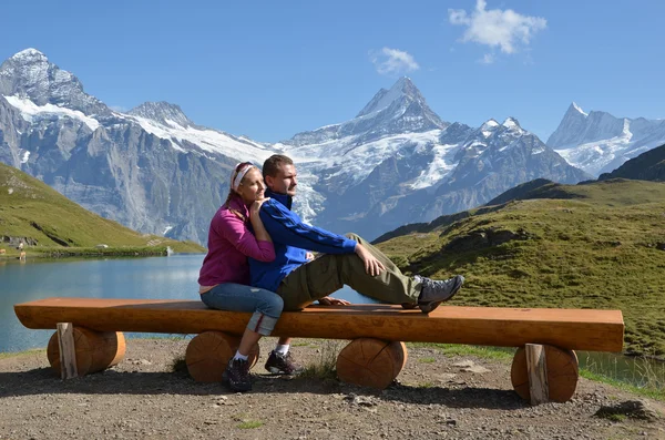 Reisende auf einer Bank genießen das Alpenpanorama. Dschungel, — Stockfoto