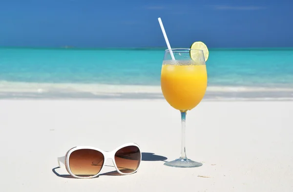 Jugo de naranja y gafas de sol en la playa. Exuma, Bahamas — Foto de Stock