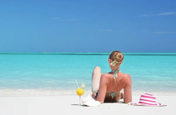 Menina com um copo de suco de laranja na praia de Exuma, Bahamas — Fotografia de Stock