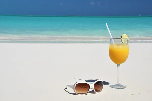 Sumo de laranja e óculos de sol na praia. Exuma, Bahamas — Fotografia de Stock