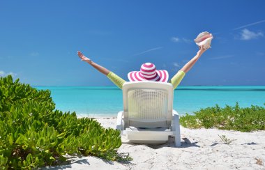 okyanusa bakarak şezlong üzerinde bir kabuk olan kız. Exuma, bah