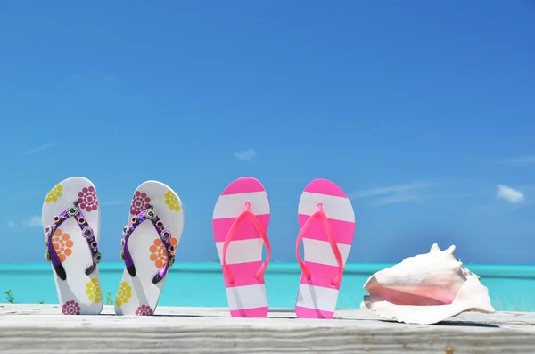 Two pairs of flip-flops against ocean. Exuma, Bahamas — Stock Photo, Image