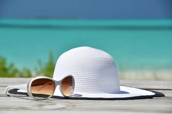 Chapéu e óculos de sol no molhe de madeira. Exuma, Bahamas — Fotografia de Stock