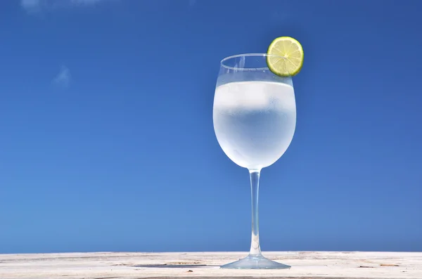 Copo de água na praia tropical — Fotografia de Stock