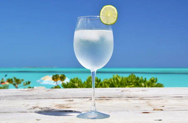 Vaso de agua en la playa tropical — Foto de Stock