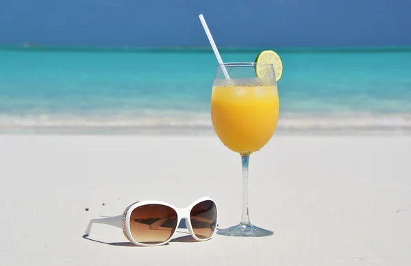 Sumo de laranja e óculos de sol na praia. Exuma, Bahamas — Fotografia de Stock