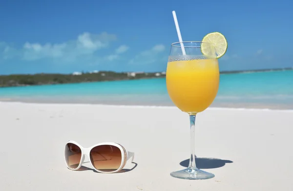 Orange juice and sunglasses on the beach. Exuma, Bahamas — Stock Photo, Image