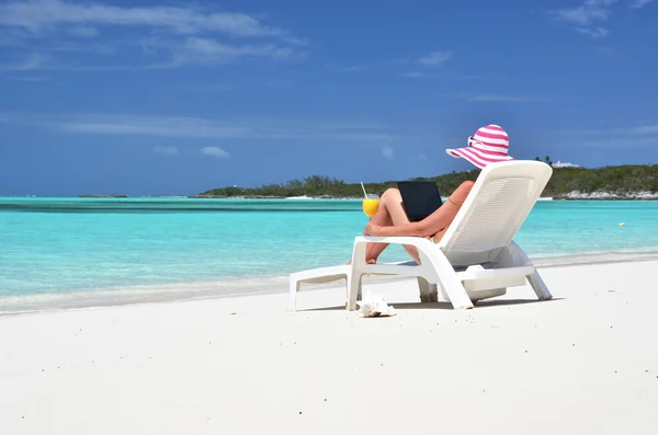 Meisje met een laptop op het tropische strand. Exuma, bahamas — Stockfoto