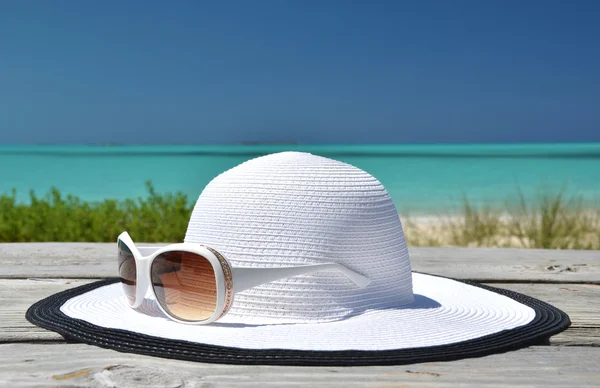 Chapéu e óculos de sol no molhe de madeira. Exuma, Bahamas — Fotografia de Stock
