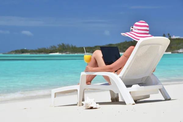 Chica con un portátil en la playa tropical. Exuma, Bahamas — Foto de Stock