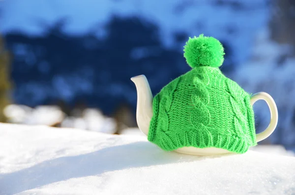 बर्फ पर बुना हुआ टोपी में चाय का बर्तन — स्टॉक फ़ोटो, इमेज