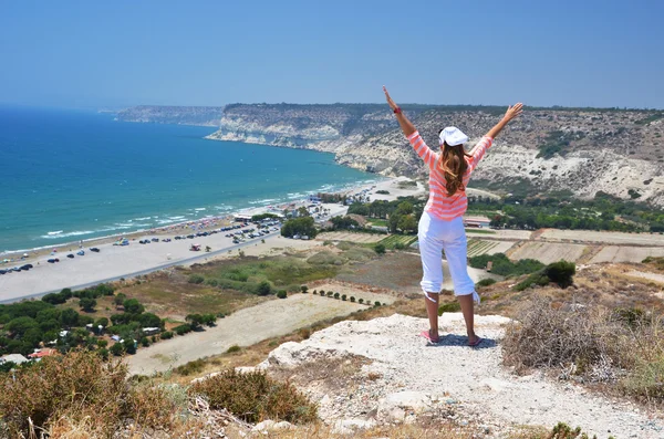 Pigen på klippen kigger ud mod havet. Cypern - Stock-foto