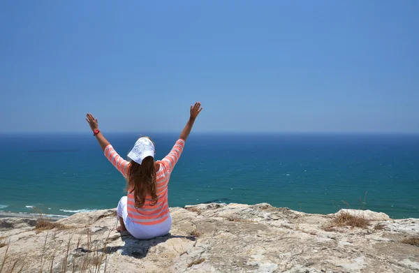 Девушка на скале смотрит на океан. Кипр — стоковое фото