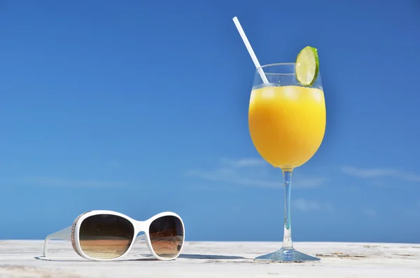 Jugo de naranja y gafas de sol — Foto de Stock