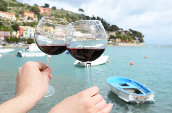 Twee wijnglazen in de handen tegen de haven van portvenere, — Stockfoto