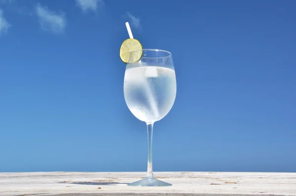青い空を背景に水の入ったグラス — ストック写真