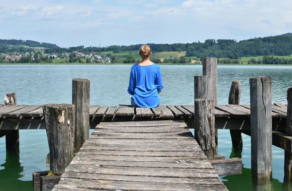 Girl on the wooden jetty. Switzerland — Stock Photo, Image