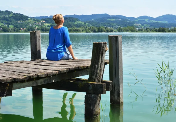 Girl on the wooden jetty. Switzerland — Stock Photo, Image